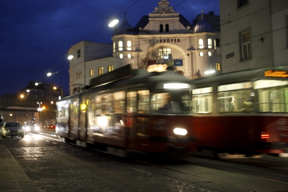 Straßenbahn in der Abenddämmerung vor der Wiener Volksoper.