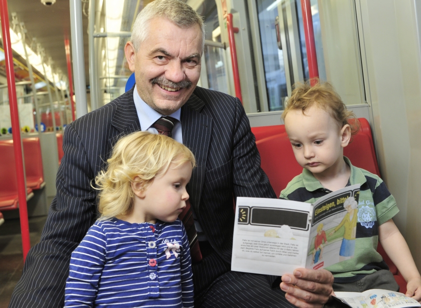 Wiener Linien Geschäftsführer Günter Steinbauer präsentiert mit zwei U-Bahn begeisterten Kindern das Wiener Linien-Kinderbuch „Einsteigen, bitte! Sicher unterwegs mit den Wiener Linien“.
