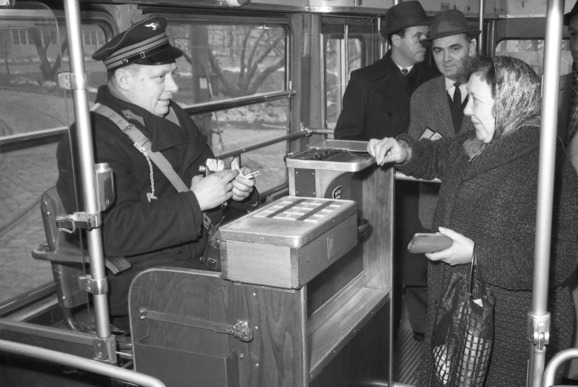 Schaffner in einem Triebwagen der Type E am Schaffnersessel beim markieren mit Mako-Zange eines Fahrscheines in 60er Jahre