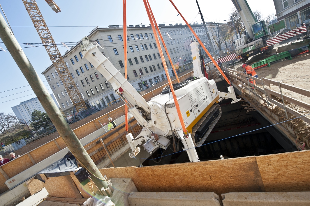 Baustelle U1 Verlängerung der Wiener Linien an der Favoritenstraße Ecke Klausenburgerstraße. Im Bild: Schweres Bohrgerät wird mit Spezialkran in Baugrube abgesenkt.