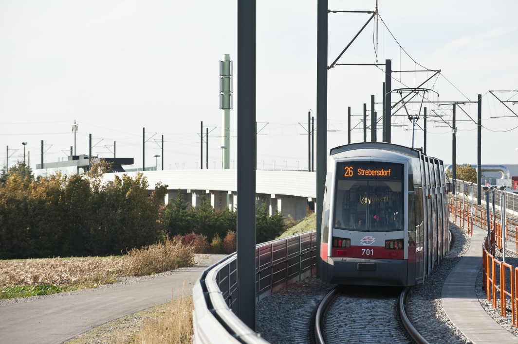 Straßenbahn der Linie 26 auf der Strecke kurz vor der Haltestelle Gewerbepark Stadlau, die in Hochlage liegt.