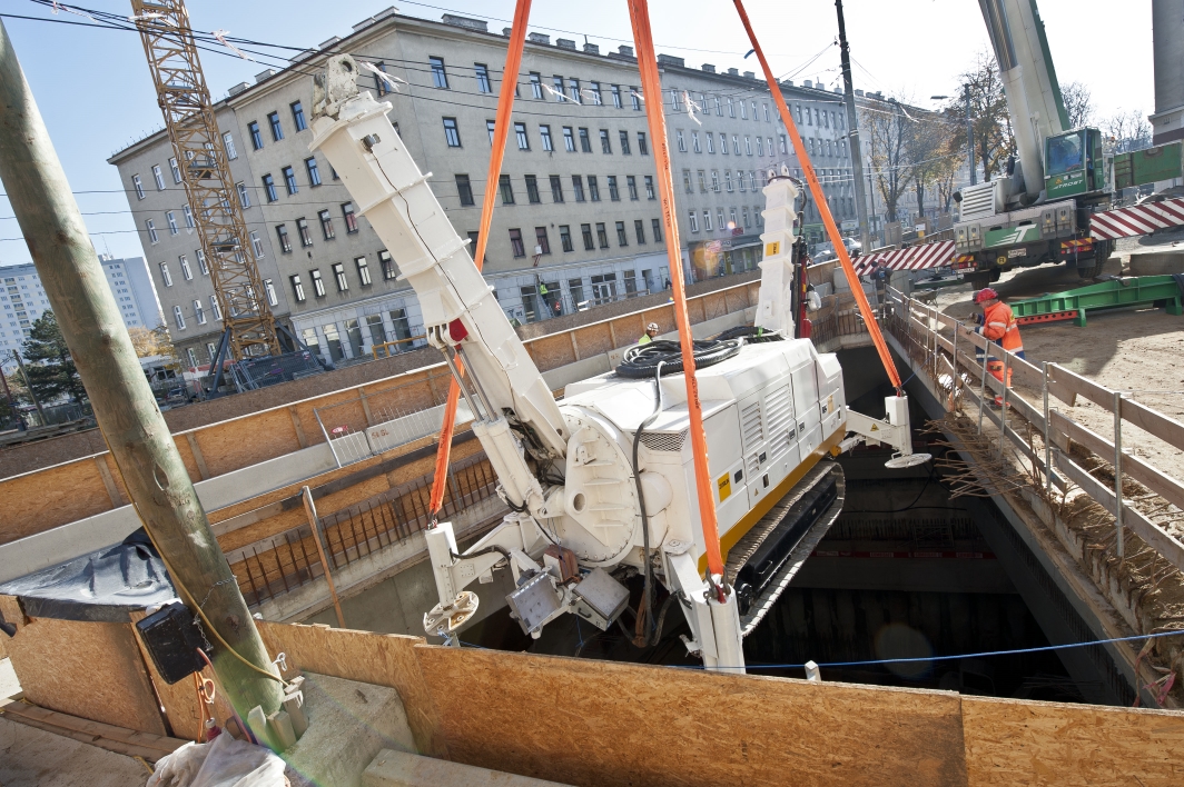 Baustelle U1 Verlängerung der Wiener Linien an der Favoritenstraße Ecke Klausenburgerstraße. Im Bild: Schweres Bohrgerät wird mit Spezialkran in Baugrube abgesenkt.