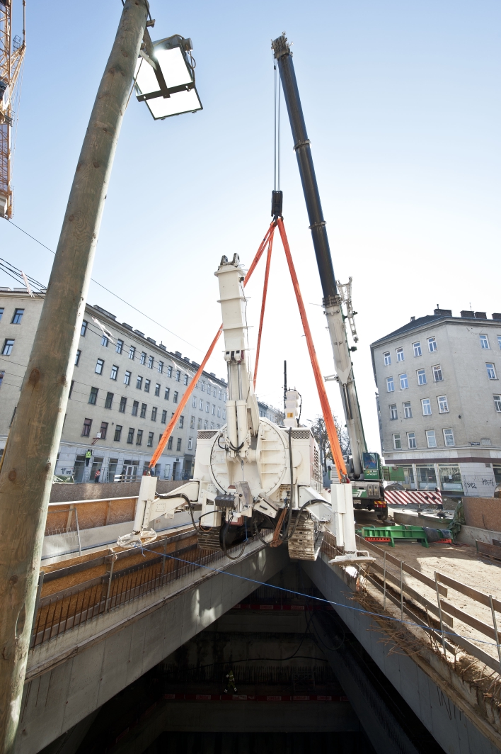 Baustelle U1 Verlängerung der Wiener Linien an der Favoritenstraße Ecke Klausenburgerstraße. Im Bild: Schweres Bohrgerät wird mit Spezialkran in Baugrube abgesenkt.