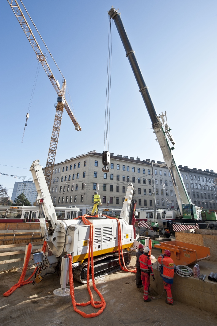 Baustelle U1 Verlängerung der Wiener Linien an der Favoritenstraße Ecke Klausenburgerstraße. Im Bild: Schweres Bohrgerät wird mit Spezialkran in Baugrube abgesenkt.