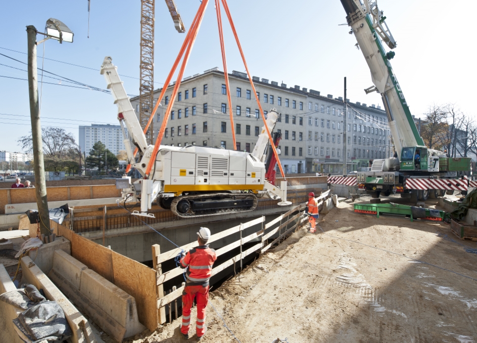 Baustelle U1 Verlängerung der Wiener Linien an der Favoritenstraße Ecke Klausenburgerstraße. Im Bild: Schweres Bohrgerät wird mit Spezialkran in Baugrube abgesenkt.