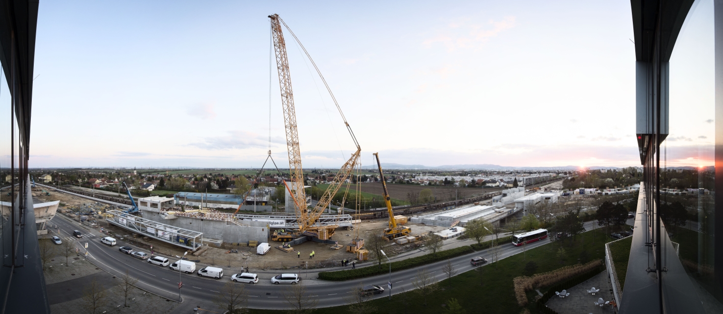 Baustelle der U1-Verlängerung in Oberlaa mit Schwerlastkran. Hebearbeiten von Fußgängersteg über die ÖBB-Gleisanlage werden vorbereitet.