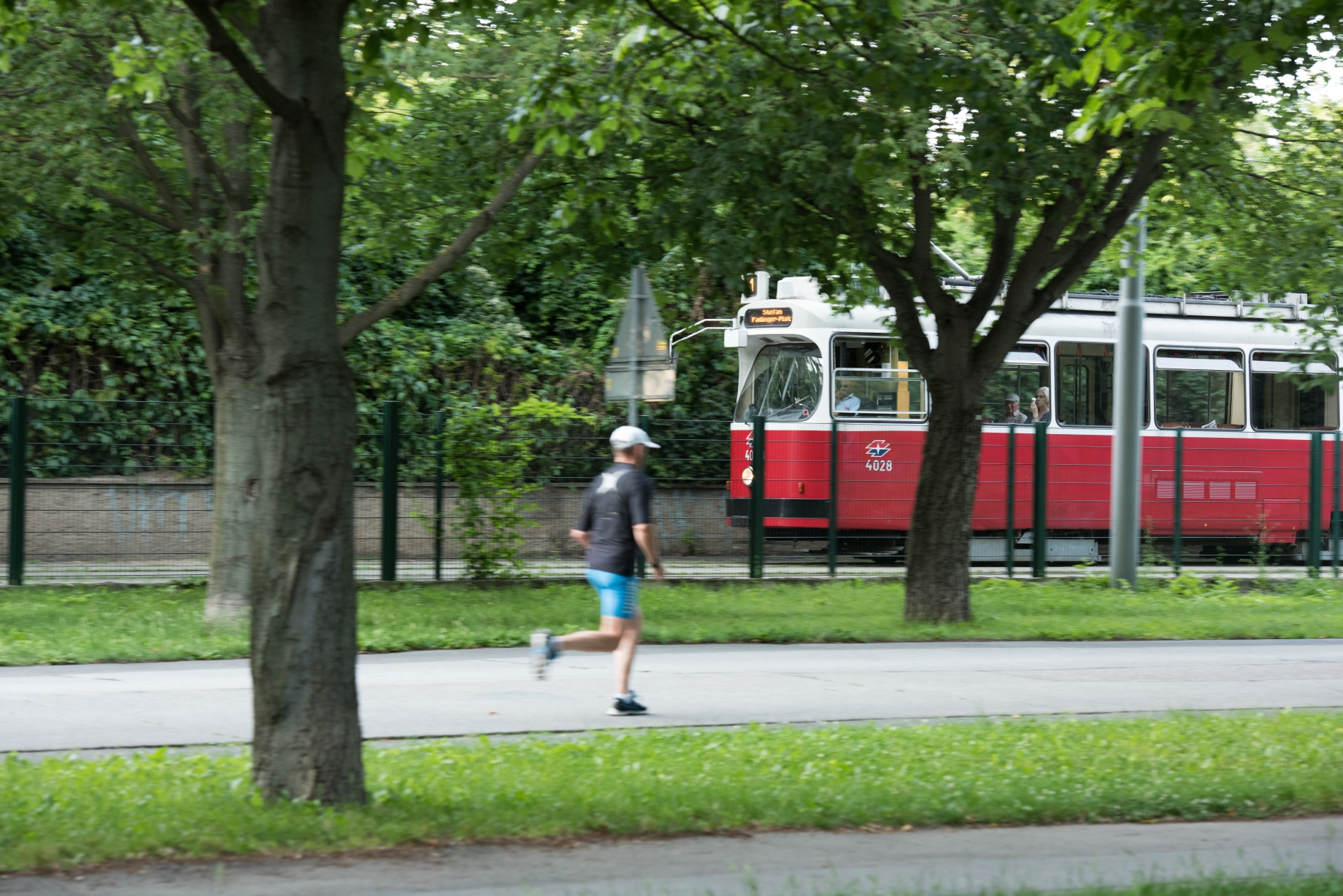 Straßenbahnlinie 1 Vorbeifahrt Jesuitenwiese, Jogger im Vordergrund