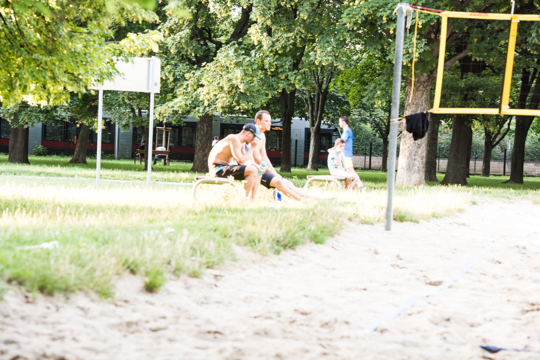 Straßenbahnlinie 1 Vorbeifahrt Jesuitenwiese, Menschen im Vordergrund beobachten ein Volleyballmatch