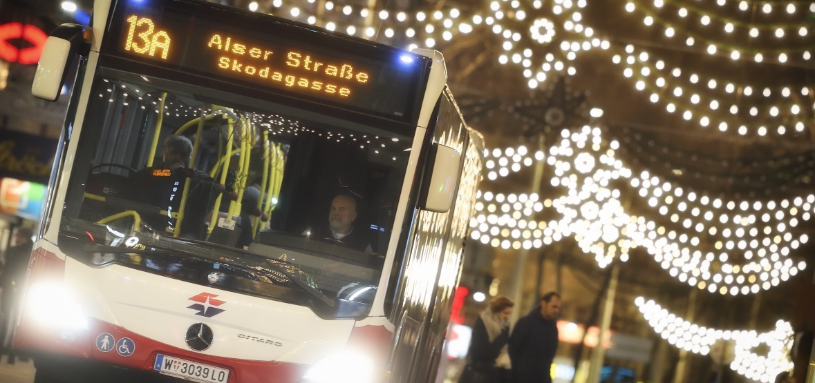 Fahrzeuge der Wiener Linien im weihnachtlich beleuchteten Wien. Hier ein Bus der Linie 13A auf der Mariahilfer Straße.