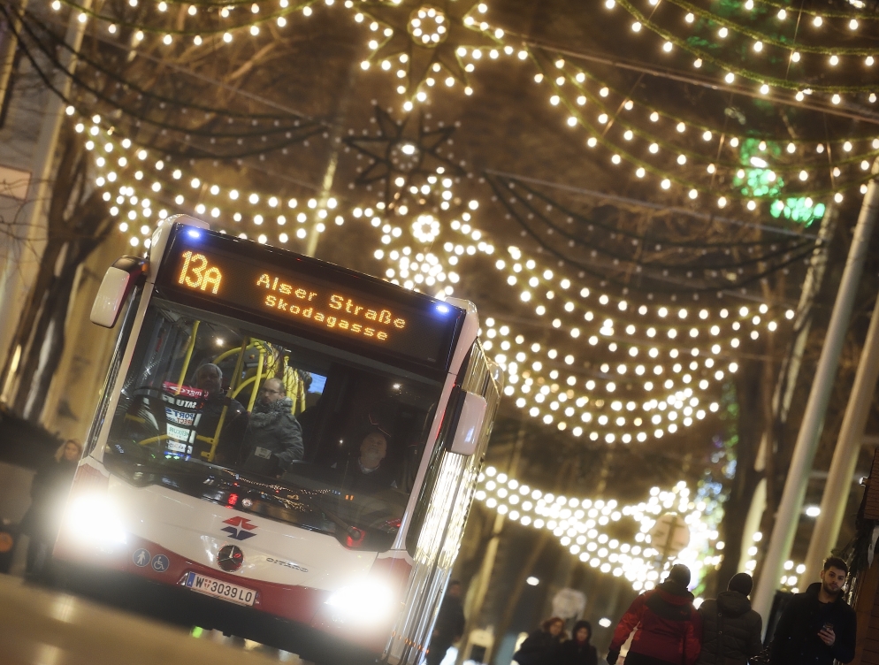 Fahrzeuge der Wiener Linien im weihnachtlich beleuchteten Wien. Hier ein Bus der Linie 13A auf der Mariahilfer Straße.