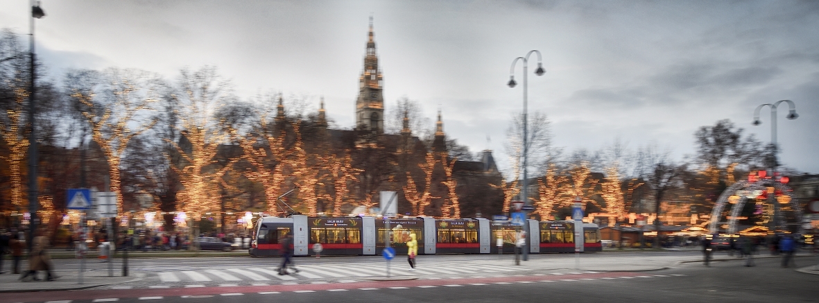 Fahrzeuge der Wiener Linien im weihnachtlich beleuchteten Wien. Hier eine Straßenbahn vor dem Rathausplatz.