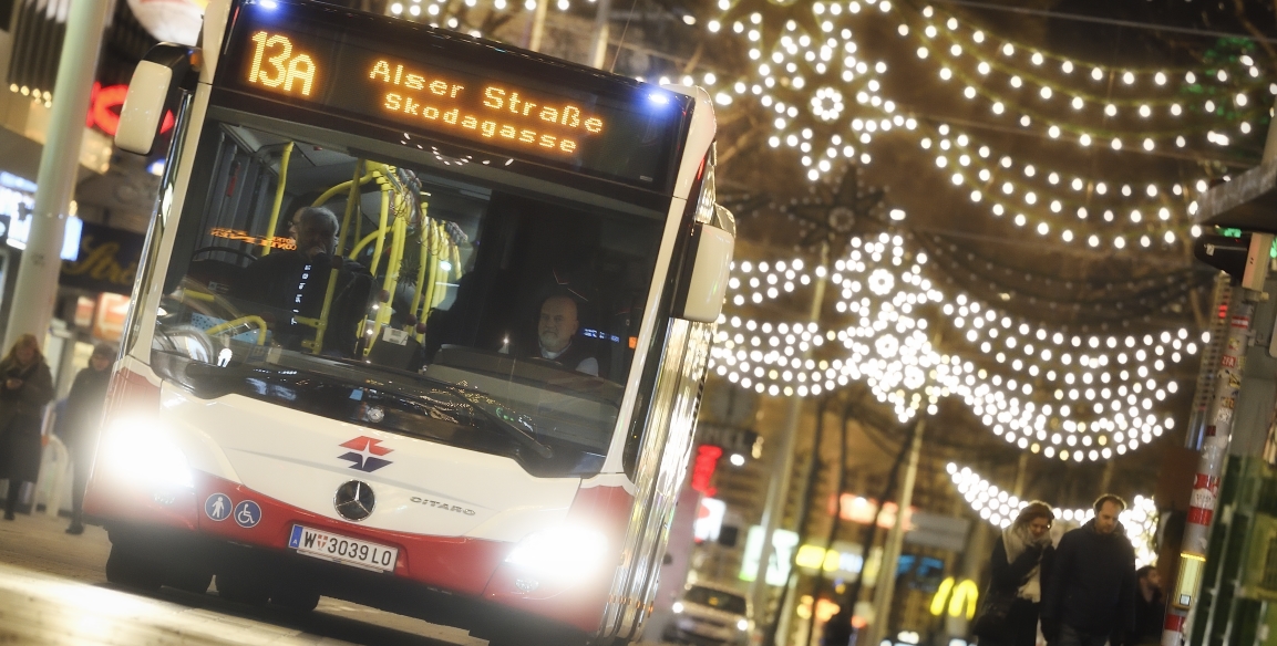 Fahrzeuge der Wiener Linien im weihnachtlich beleuchteten Wien. Hier ein Bus der Linie 13A auf der Mariahilfer Straße.