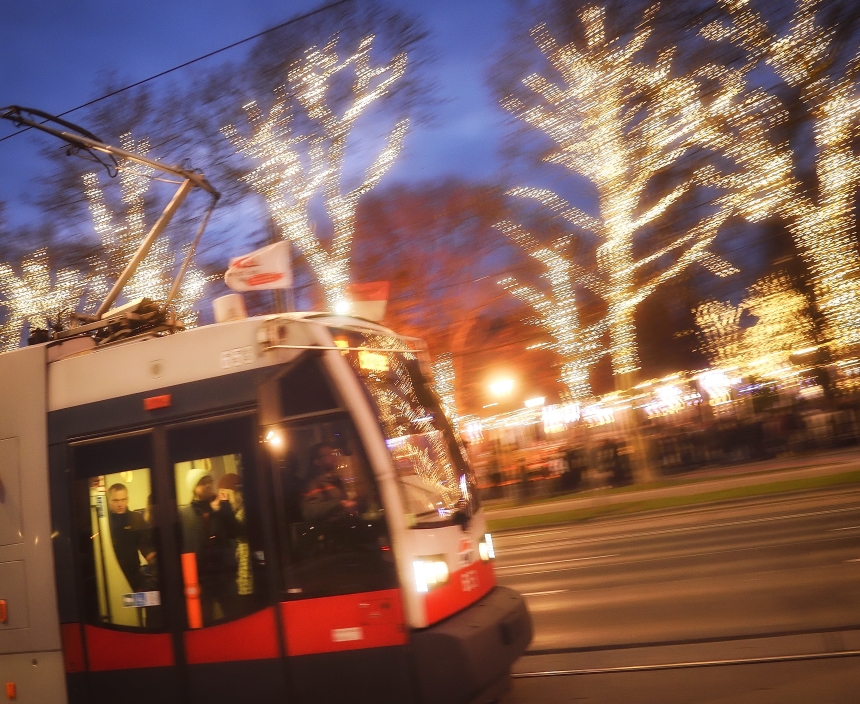 Fahrzeuge der Wiener Linien im weihnachtlich beleuchteten Wien. Hier eine Straßenbahn vor dem Rathausplatz.