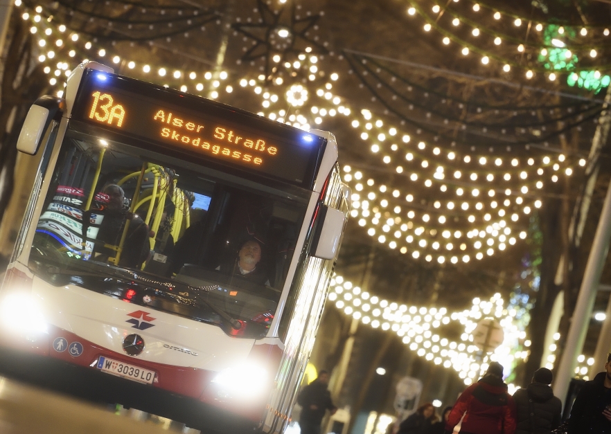 Fahrzeuge der Wiener Linien im weihnachtlich beleuchteten Wien. Hier ein Bus der Linie 13A auf der Mariahilfer Straße.