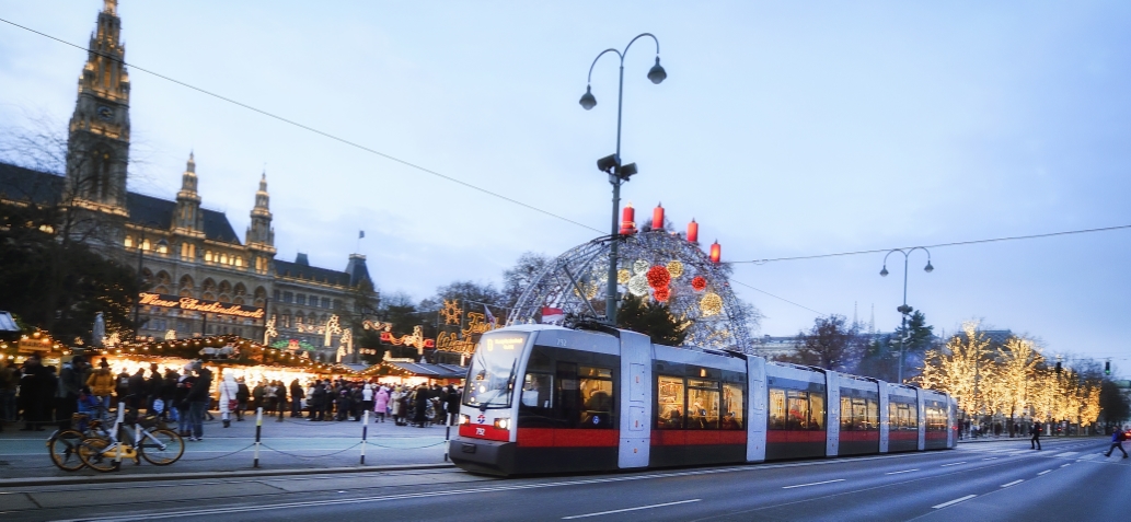 Fahrzeuge der Wiener Linien im weihnachtlich beleuchteten Wien. Hier eine Straßenbahn vor dem Rathausplatz.