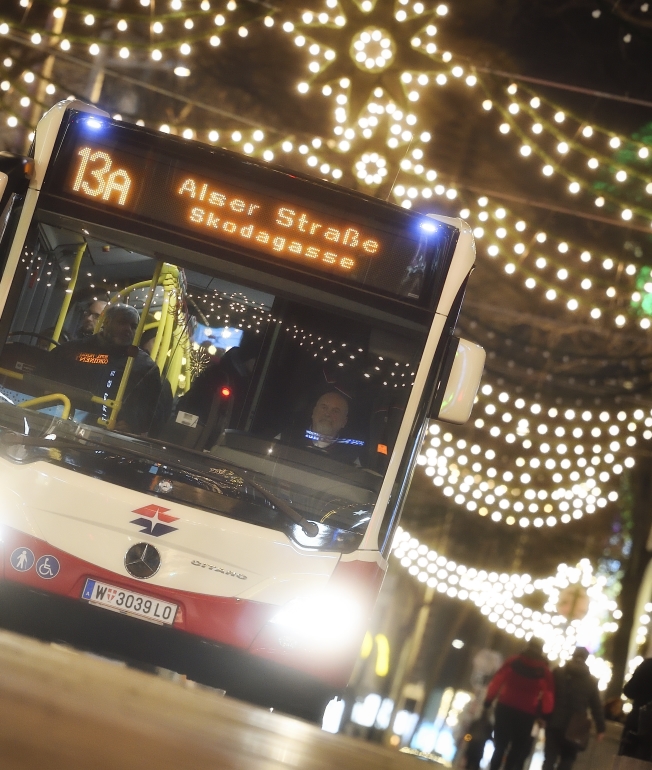 Fahrzeuge der Wiener Linien im weihnachtlich beleuchteten Wien. Hier ein Bus der Linie 13A auf der Mariahilfer Straße.